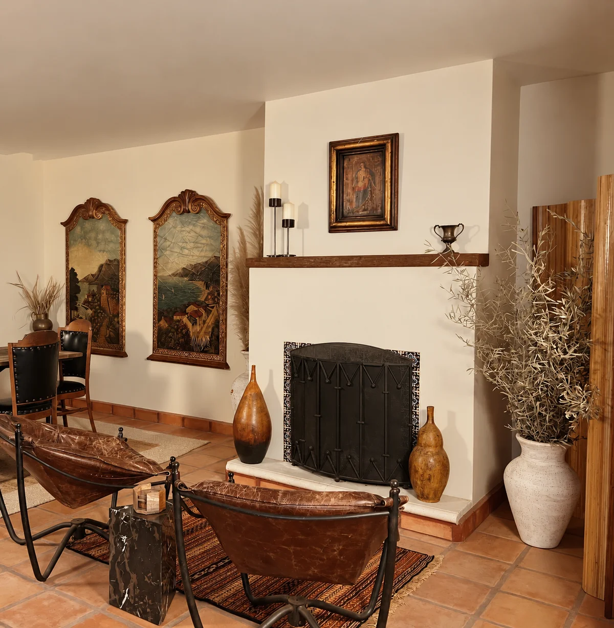 Two framed landscape paintings above a plaster fireplace with a dark screen, a hammered copper basin on a stand in the foreground and tall earthenware vessels either side.